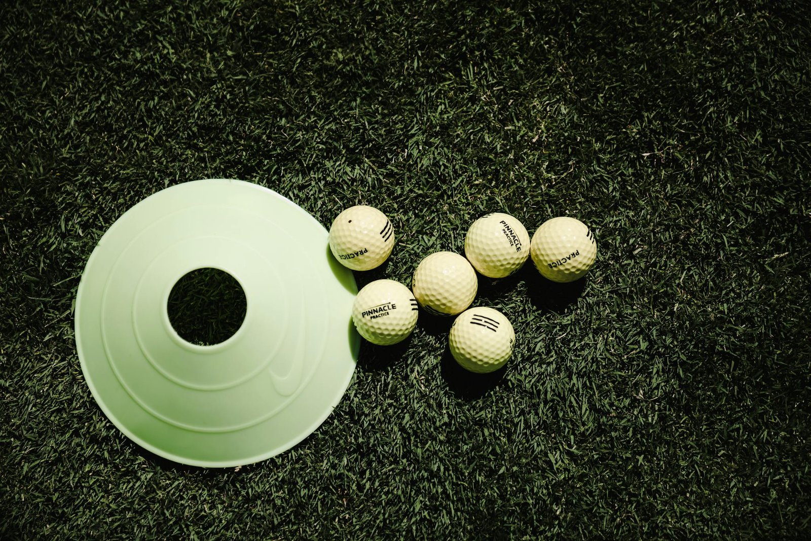 Balles de golf et cône d'entraînement sur gazon